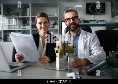 Robotics engineers working on laptop and desinging modern robotic machine in laboratory. Stock Photo