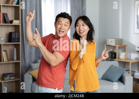 Funny asian man and woman having good time at home Stock Photo