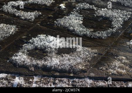 Thermal differences of heat in boundary of patio slabs become evident as fresh snow fall melts on the perimeter, or concentration of chemicals Stock Photo