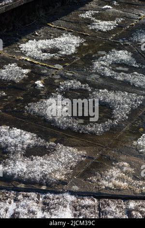 Thermal differences of heat in boundary of patio slabs become evident as fresh snow fall melts on the perimeter, or concentration of chemicals Stock Photo
