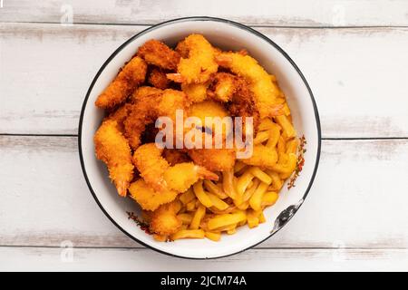 A large bowl filled with homemade crispy tempura shrimp and french fries. Close-up, top view. Asian cuisine. Stock Photo