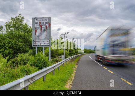 Belfast, UK. 14th June, 2022. A vehicle moves past a border sign near Newry, Northern Ireland, the United Kingdom, on June 14, 2022. The United Kingdom (UK) on Monday introduced a bill to change parts of the Northern Ireland Protocol, a post-Brexit trade deal, while the European Union (EU) said unilateral action is damaging to mutual trust and threatened legal action.TO GO WITH 'Roundup: UK reveals plan to change N. Ireland Protocol as EU threatens legal action ' Credit: Colum Lynch/Xinhua/Alamy Live News Stock Photo