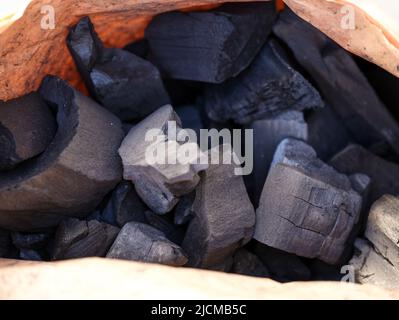 A Close-up shot of charcoal pieces in a paper bag Stock Photo