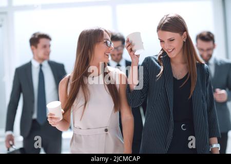 employees with cups of coffee discussing something during a work break Stock Photo