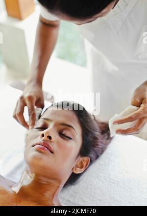 A young woman receives a Nourishing Pink Clay Facial treatment at a spa in Sri Lanka. Stock Photo