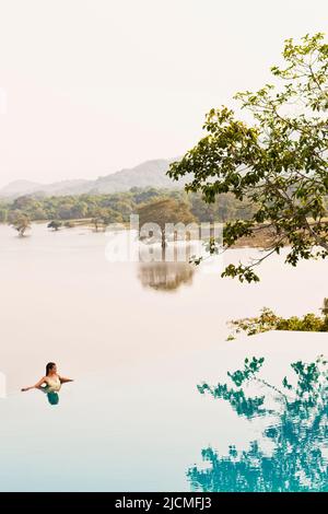 Woman in Infinity Pool at a hotel. Dambulla, Sri Lanka. Stock Photo