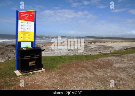 Right at the end of the car park is a location sign with instructions should you need the emergency services, right in front is a double itter bin. Stock Photo