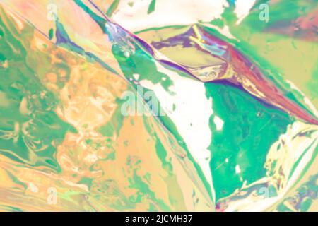 Blurred holographic background. Defocused multicolored texture of wrinkled foil. Stock Photo