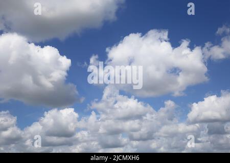 Isolated blue summer sky cloudscape photo with white fluffy fair weather cumulus clouds Stock Photo