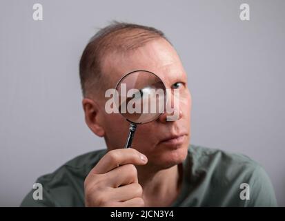 Eye problem, disease concept. Pain, ache and eyesight checking. Woman with magnifying lens. High quality photo Stock Photo