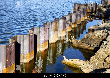 Temporary corrugated steel plate retaining wall during the strengthening and reconstruction of the river bank Stock Photo