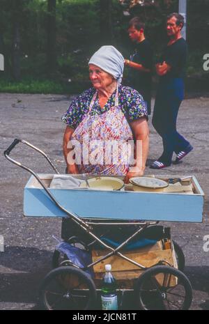 Women using converted baby carriages selling food to passenegers on Trans Siberian railroad. When train makes a stop here, passengers often buy food from these vendors to eat when coninuing their trip on the train.. Stock Photo