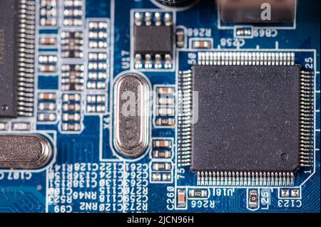 macro close-up shot of microchip on blue printed circuit board, computer motherboard with components Stock Photo