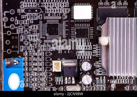 macro close-up shot of microchip on black printed circuit board, computer vide ocard with components Stock Photo