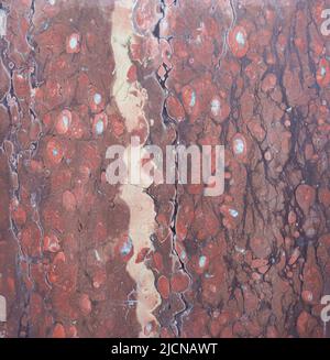 Red marble with large white flecks and vertical veins Stock Photo