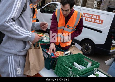 Glasgow, UK, 14 June 2022. People avail themselves of free food at at foodbank, run by the Go Dharmic #FeedEveryone campaign, which distributes 1000’s of meals across the country & strives towards minimising the #hunger crisis. A weekly event in George Square, in Glasgow, Scotland, on 14 June 2022. Photo credit: Jeremy Sutton-Hibbert/Alamy Live News. Stock Photo