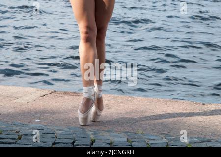 Legs of a female ballet dancer practising on the street with pointe shoes. Tomsk Stock Photo