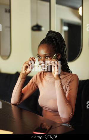 Tired, exhausted afro american businesswoman or student, lying table at laptop in cafe. Meet deadline, need sleep, rest Stock Photo