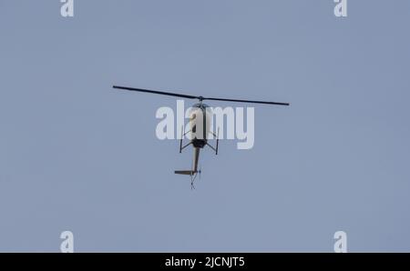 helicopter in flight against the background of blue sky during sunset Stock Photo