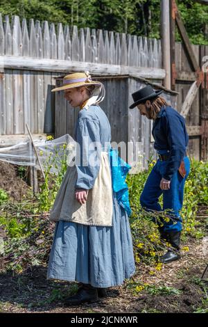 woman and man working at the garden at Fort Nisqually while wearing historical clothing from the 1850s Stock Photo