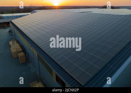 Aerial view of blue photovoltaic solar panels mounted on industrial building roof for producing green ecological electricity. Production of Stock Photo