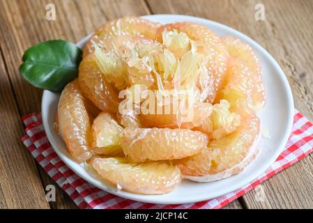 Pomelo fruit on white plate, fresh pomelo peeled frome pomelo tree , pummelo , Cloce up grapefruit in summer tropical fruit  in thailand Stock Photo