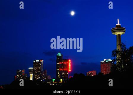 A full moon rises over the hotels and observation towers that make up the skyline of Niagara Falls, Ontario, Canada Stock Photo