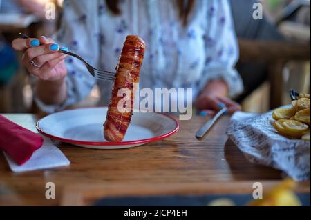 https://l450v.alamy.com/450v/2jcp4eh/midsection-of-woman-holding-fork-with-pork-meat-wrapped-in-bacon-2jcp4eh.jpg