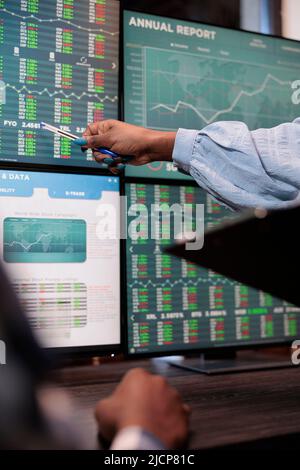 Close up shot of financial advisor pointing out downtrend of market while reviewing real time trading data. Forex stock analyst signaling trade option exit in order to gain full profits. Stock Photo
