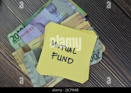 Concept of Mutual Fund write on sticky notes isolated on Wooden Table. Stock Photo