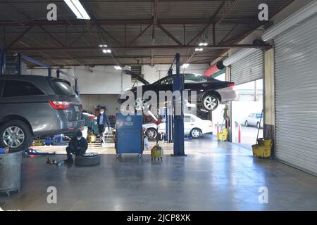 Cars on rack in auto repair shop Stock Photo - Alamy