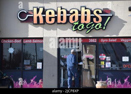 Bug exterinator walking in front of a Kebabs to Go store in Irving, Texas Stock Photo