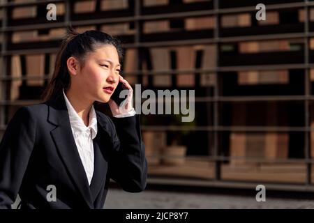 serious asiatic businesswoman talking on the phone Stock Photo
