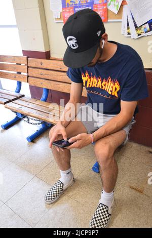 Young Gen Z man (Generation Z) looking down at his cell phone Stock Photo