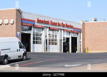 Open garage doors at a Firestone auto repair shop; white van parked on left side Stock Photo