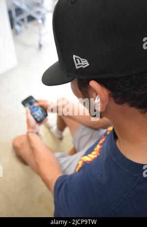 Young Gen Z man (Generation Z) looking down at his cell phone Stock Photo