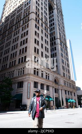 African American man walking across the street from the Magnolia Hotel in downtown Dallas, Texas ca. 2013 Stock Photo