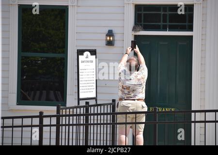 A tourist taking a photo with his cell phone of a nest filled with baby birds Stock Photo