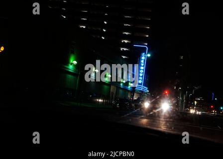 Oncoming car headlights at night in front of the Greyhound bus station in downtown Dallas Texas Stock Photo