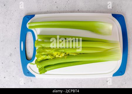 Stalk of celery close-up on cutting board, view from above, copy space Stock Photo