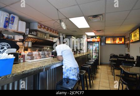 A hungry customer, wearing a mask, waits for her food at the Record Grill in downtown Dallas, Texas Stock Photo