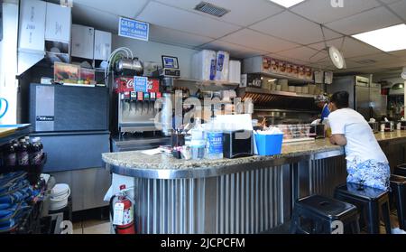 A hungry customer, wearing a mask, waits for her food at the Record Grill in downtown Dallas, Texas Stock Photo