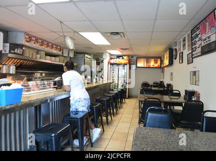 A hungry customer, wearing a mask, waits for her food at the Record Grill in downtown Dallas, Texas Stock Photo