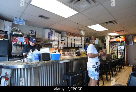 A hungry customer, wearing a mask, waits for her food at the Record Grill in downtown Dallas, Texas Stock Photo