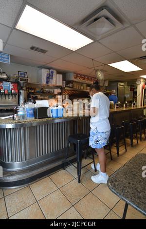 A hungry customer, wearing a mask, waits for her food at the Record Grill in downtown Dallas, Texas Stock Photo