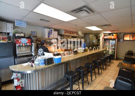 Interior of the Record Grill, a small hole in the wall restaurant, in downtown Dallas, Texas where a cook and clerk are hard at work on pick up orders Stock Photo