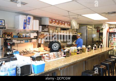 Interior of the Record Grill, a small hole in the wall restaurant, in downtown Dallas, Texas where a cook and clerk are hard at work on pick up orders Stock Photo