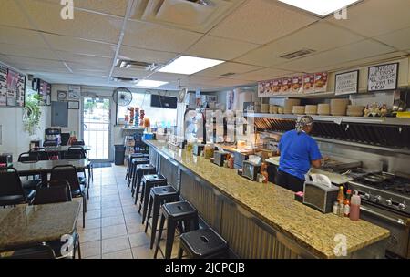 Interior of the Record Grill, a small hole in the wall restaurant, in downtown Dallas, Texas where a cook and clerk are hard at work on pick up orders Stock Photo