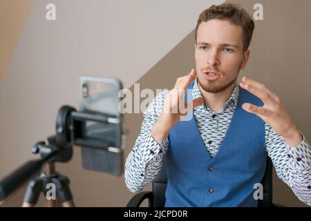 Close-up online conference of young male, professional trainer coach teacher, recording lecture presentation online, commercial blogging or vlogging concept Stock Photo