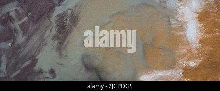 Multicolored texture of natural material. Gradient transition from gray to orange. A mixture of sand and cement. Stock Photo